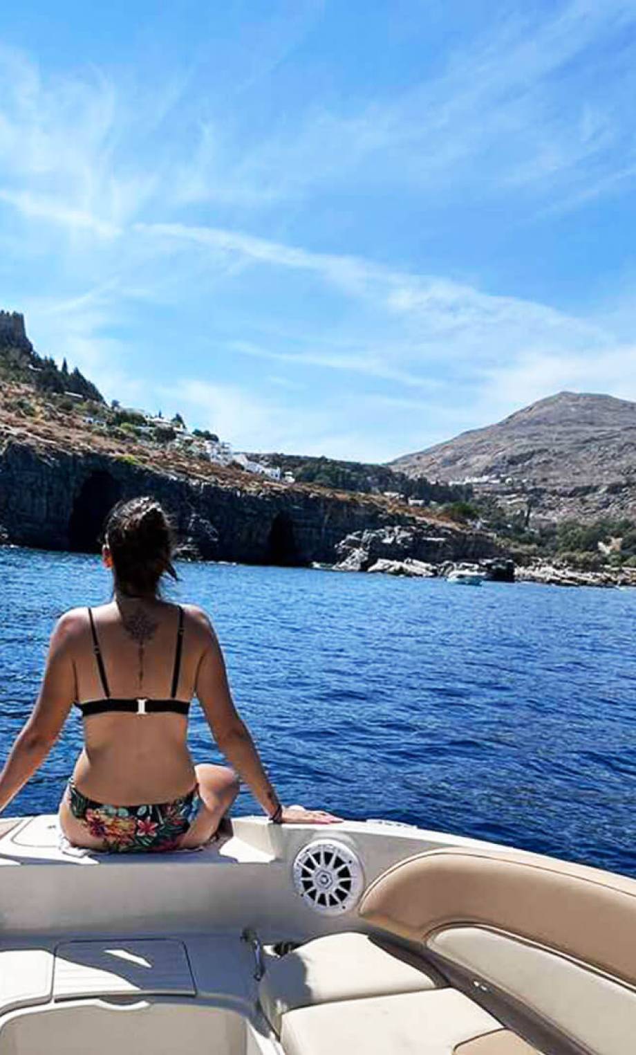Happy guest enjoying a private skippered tour in Lindos on a Sea Ray 260 speed boat